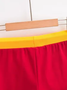 Gedetailleerde opname van de gele elastische tailleband van rode hotpants.