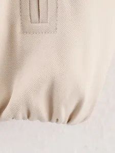 Macro-opname van de elastische zoom en twill-stoftextuur van een beige modieuze jas