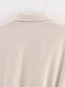 Detailopname van de beige baseballjackkraag en de hoogwaardige geweven stoftextuur.