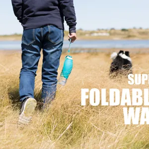 Outdoor lifestyle shot of a foldable blue pet water bottle used during a dog walk