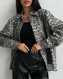 Close-up of retro leopard print denim jacket with lapel and silver metal buttons.