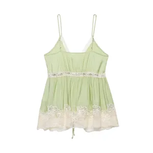 Close-up detail of the delicate white lace trim on a light green lingerie-style camisole top