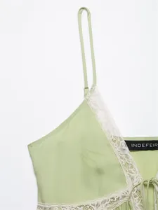 Detailed view of the delicate white lace trim on a light green camisole top