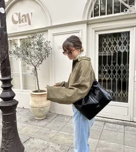 Détail d'une veste bomber élégante à manches chauve-souris vert olive pour femme dans la rue