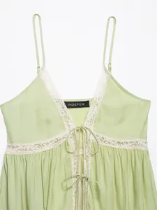 Close-up of light green lace-trimmed camisole top with V-neck and tie-front detail