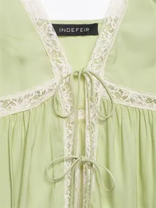 Close-up detail of sage green lace camisole with elegant tie-front and floral trim.
