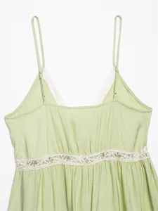 Close-up detail of a light green camisole top with delicate white lace trim and straps