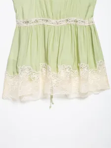 Detailed close-up of a sage green lingerie-style top with delicate white lace trim