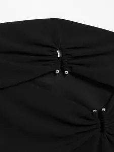 Detailansicht eines schwarzen schulterfreien Oberteils mit Cut-out und Silberperlen.
