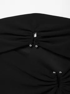Makroansicht eines schwarzen Schlauchoberteils mit Ausschnitt-Design und Silberperlen.
