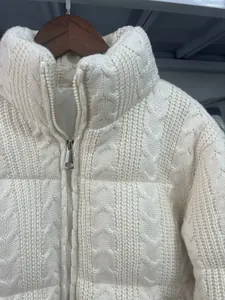 Detailaufnahme einer cremefarbenen Zopfstrick-Steppjacke mit Stehkragen