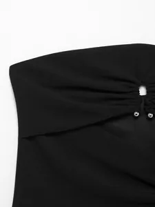 Nahaufnahme eines schwarzen trägerlosen Schlauchoberteils mit Ausschnitt und Silberperlen