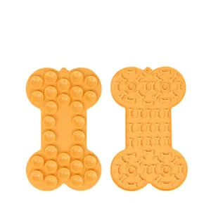 Bone-shaped orange silicone slow feeder lick mat for dogs with suction cups