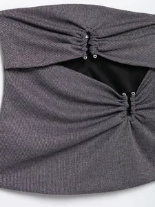 Nahaufnahme eines schimmernden lila Tube-Tops mit modischen Cut-Outs und Perlen.