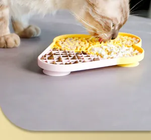 Détail d'un chat utilisant un tapis de léchage bicolore en silicone pour animaux