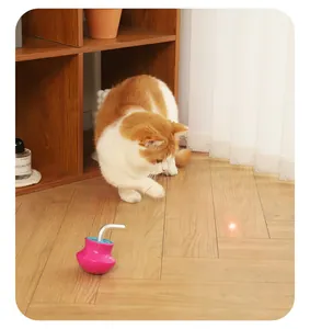 Ginger cat interacting with a red laser point from an automatic pink tumbler toy