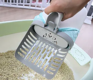 Detail view of integrated cat litter scoop with waste bag dispenser over litter box