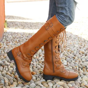 Vista lateral detallada de botas altas marrones con hebillas de metal y diseño de cordones