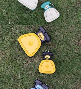 Detail view of portable folding pet pooper scoopers displayed on natural green grass background