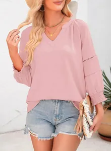 Detail der rosa V-Ausschnitt-Bluse mit Spitzendetails und gerafften Ärmeln für den Urlaub