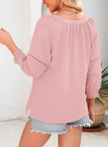Rückansicht einer rosa Bluse mit Spitzendetails und plissierten Manschetten