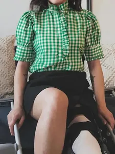Primo piano di una camicia a quadretti verde e bianca vintage con maniche a sbuffo