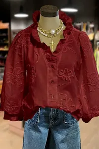 Detailed view of maroon V-neck blouse with floral embroidery and puff sleeves