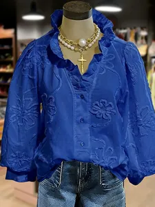 Blue V-neck blouse with floral embroidery and elegant ruffled puff sleeves detail
