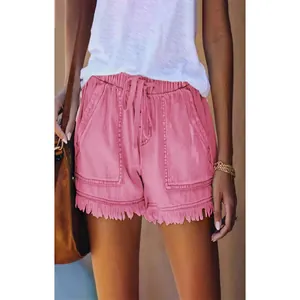 Detail view of pink high-waisted denim shorts with frayed hems and drawstring.