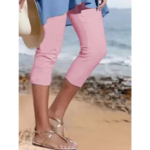 Detailansicht der einfarbigen rosa Capri-Leggings für Damen in einer Strandumgebung