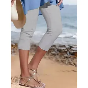 Detailansicht der grauen, atmungsaktiven Damen-Capri-Leggings am sonnigen Strand.