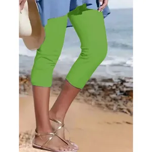 Detailansicht der leuchtend grünen, atmungsaktiven Capri-Leggings für Damen am Strand