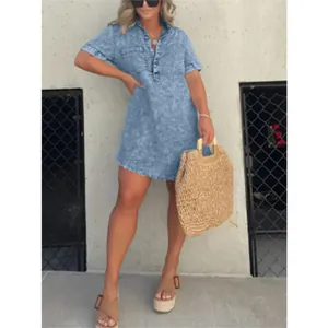 Détail d'une robe chemise en jean bleu avec un ourlet à franges et des manches courtes