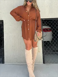 Detailansicht eines braunen Damen-Jumpsuits mit Tunnelzug in der Taille und Stiefeln.