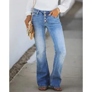 Dettaglio di jeans a zampa a vita alta con bottoni multipli in denim blu slavato.