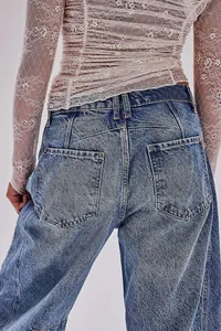 Macro view of blue washed wide leg denim jeans featuring stylish beige lace top