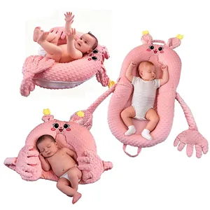 Pink portable baby lounger nest with plush minky dot fabric and soothing cartoon design