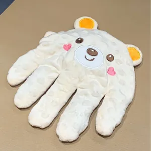 Detalle de la palma calmante para bebés con suave tejido minky y cara de oso bordada
