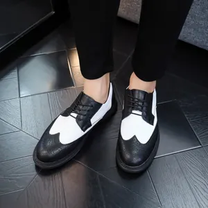 Detailed macro view showing the wingtip design of men's black and white brogue leather shoes