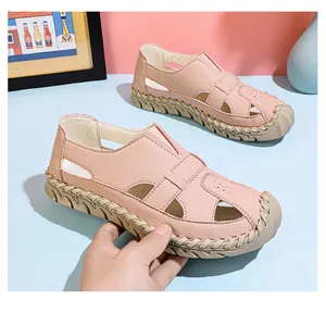 Detailansicht von rosa handgenähten Sommersandalen mit ausgehöhltem Design und weichen Sohlen.