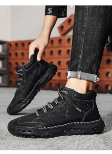 Detailed view of men's black high-top leather boots with handmade stitching details