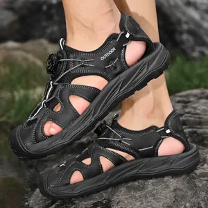 Black men's outdoor sandals with rotary buckle closure on rocky background