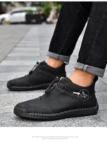 Close-up of black textured leather casual boots with hand-stitched detailing and front zipper.