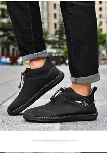 Detailed close-up of black hand-stitched outdoor casual leather boots with zipper.