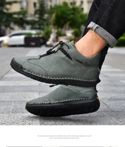 Close-up of grey hand-stitched outdoor casual leather boots featuring front zipper closure