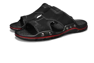 Detailaufnahme schwarzer Herren-Ledersandalen mit weißen Nähten und roter Sohle
