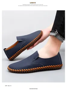 Close-up of navy blue men's slip-on shoes with orange decorative hand-stitching