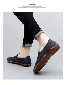 Detailed view of men's navy blue slip-on loafers featuring orange hand-stitched soles