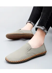 Close-up detail of gray hand-stitched men's loafers with soft sole and slip-on design