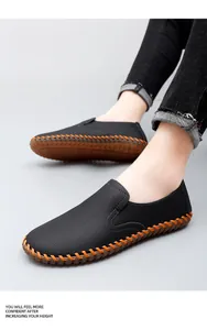 Close-up of men's black leather slip-on loafers with orange hand-stitched detailing